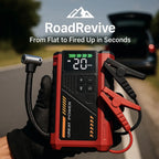 RoadRevive™ jump starter in red and black with digital display and clamps held by gloved hand at roadside.