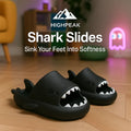 HighPeak Shark Slides in black with shark-bite design and cushy sole on wooden floor in cozy indoor setting