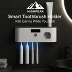 HighPeak Smart Toothbrush Holder in white mounted on black tile wall with four toothbrushes and toothpaste dispenser