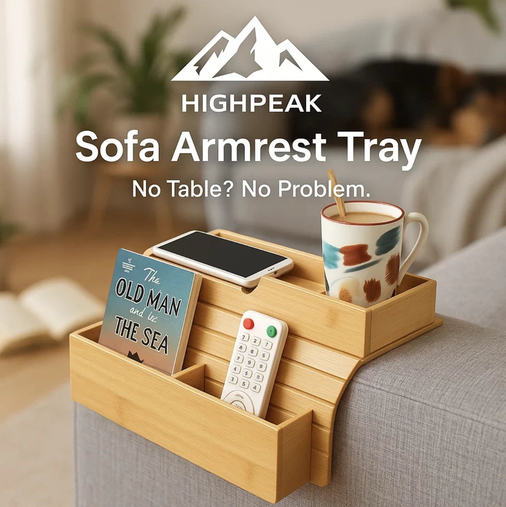 HighPeak Sofa Armrest Tray in natural bamboo holding a mug, remote, phone, and book on a gray couch armrest