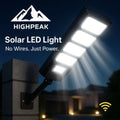 HighPeak Solar LED Light mounted on a black pole at night, emitting bright white light with wireless remote control features.