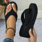 Black Solea Platform Flip Flops shown worn and held to display the toe-post straps and wedge sole