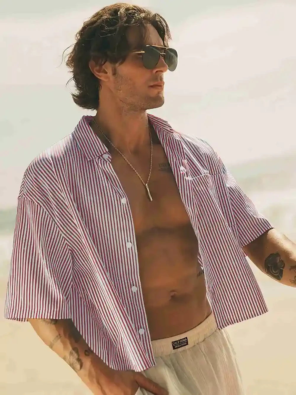 HighPeak Men’s Striped Beach Shirt in red and white, lightweight breathable fabric, worn open at the beach
