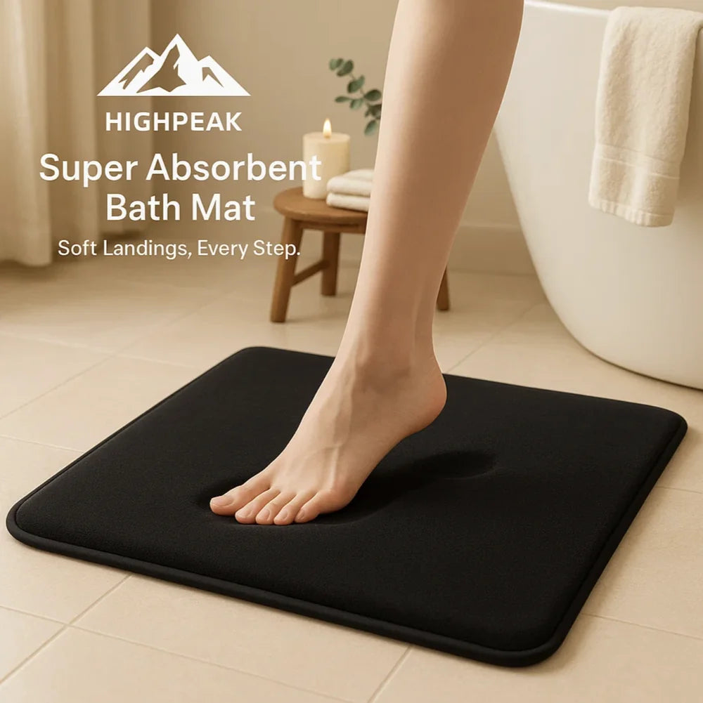 HighPeak Super Absorbent Bath Mat in black with anti-slip backing on bathroom floor under bare foot stepping down.