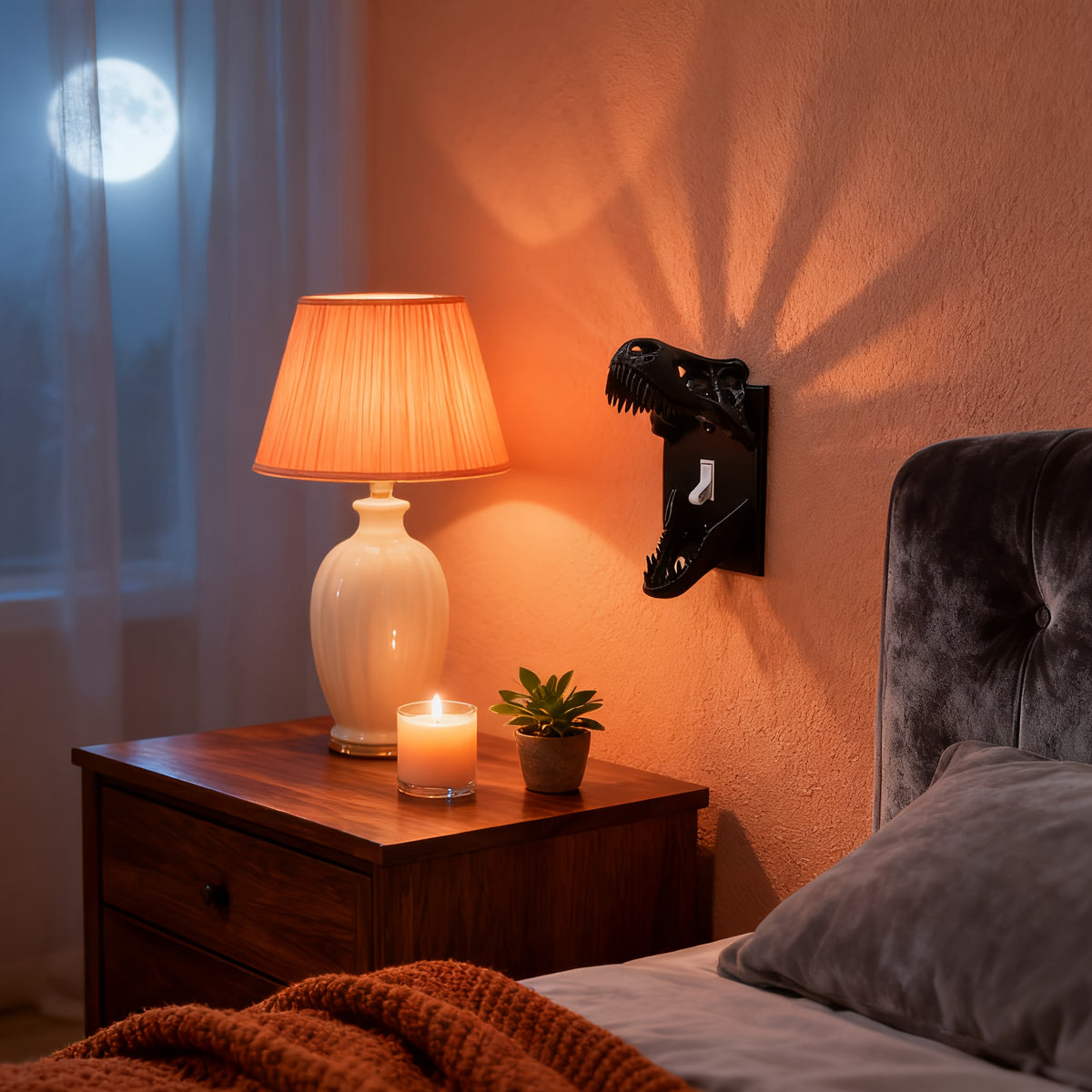 Black T-Rex Skull Switch Cover styled beside a bedside lamp in a warm bedroom