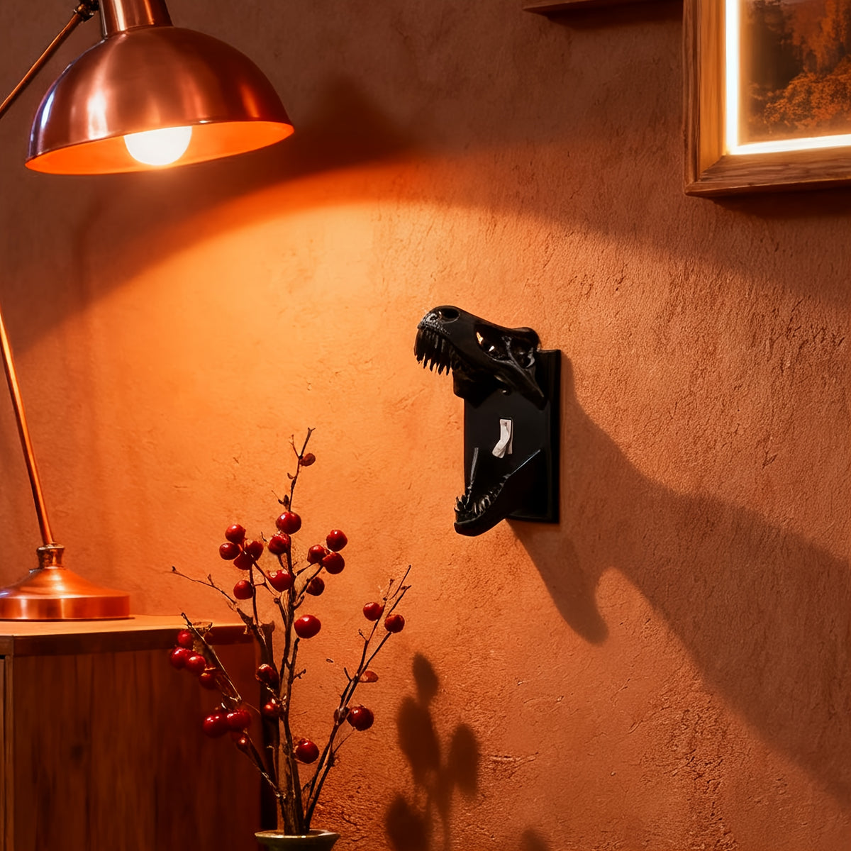 Black T-Rex Skull Switch Cover mounted beneath a lamp on a warm orange wall