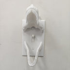 Front view of a white T-Rex Skull Switch Cover mounted around a toggle light switch