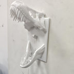 White T-Rex Skull Switch Cover mounted around a toggle light switch, angled side view