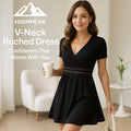 HighPeak V-Neck Ruched Dress in black with lace waist detail and pleated skirt worn indoors with casual accessories