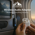 HighPeak Wireless Audio Adapter (Airplanes) plugged into airplane TV with Bluetooth earbuds syncing wirelessly.