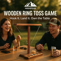 HighPeak Wooden Ring Toss Game with rustic wood base set on table outdoors, two players enjoying game and drinks