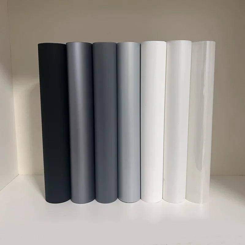 Holographic Window Projection Film supplier lineup of black, gray, white and transparent film rolls.