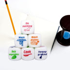 Housework Dice Game chore outcomes displayed beside a notebook and pencil on a desk