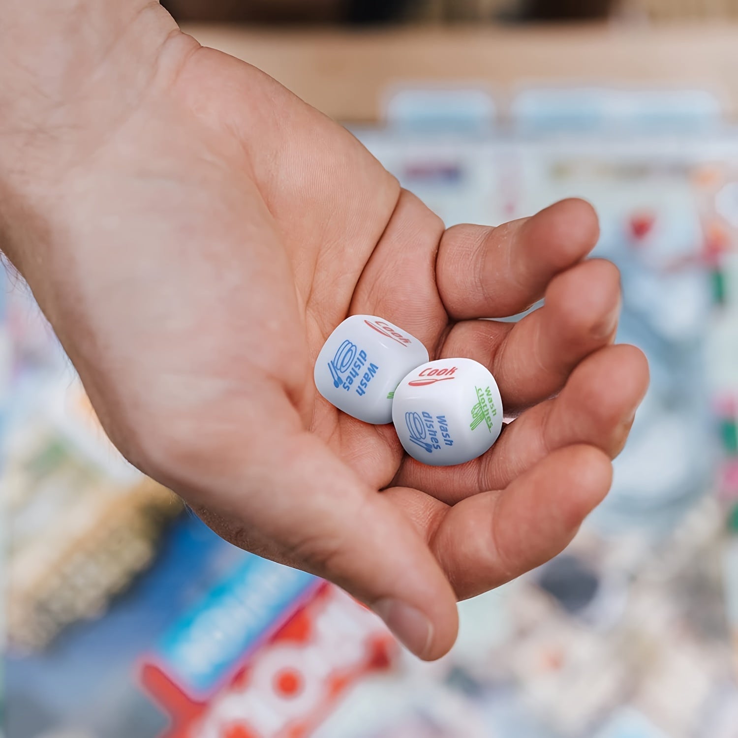 Housework Dice Game dice resting in a hand to show their compact 2 cm scale