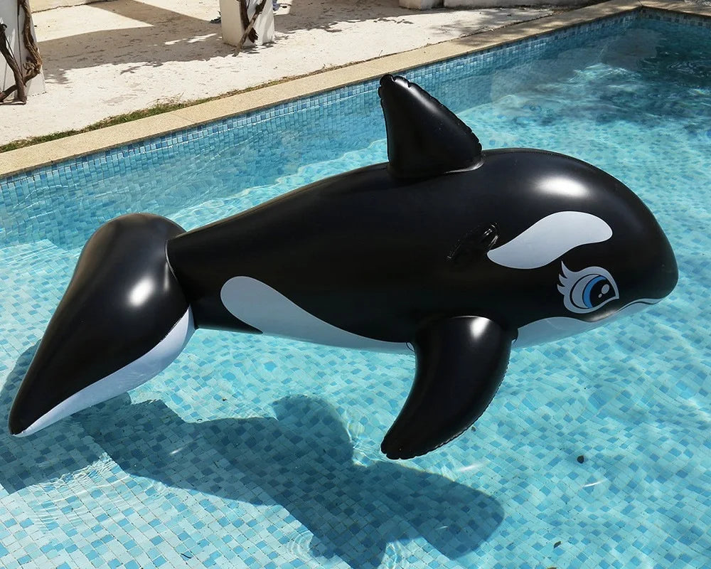Inflatable Orca Pool Float floating in a pool, showing blue eyes, grip handle, dorsal fin, side fins and tail