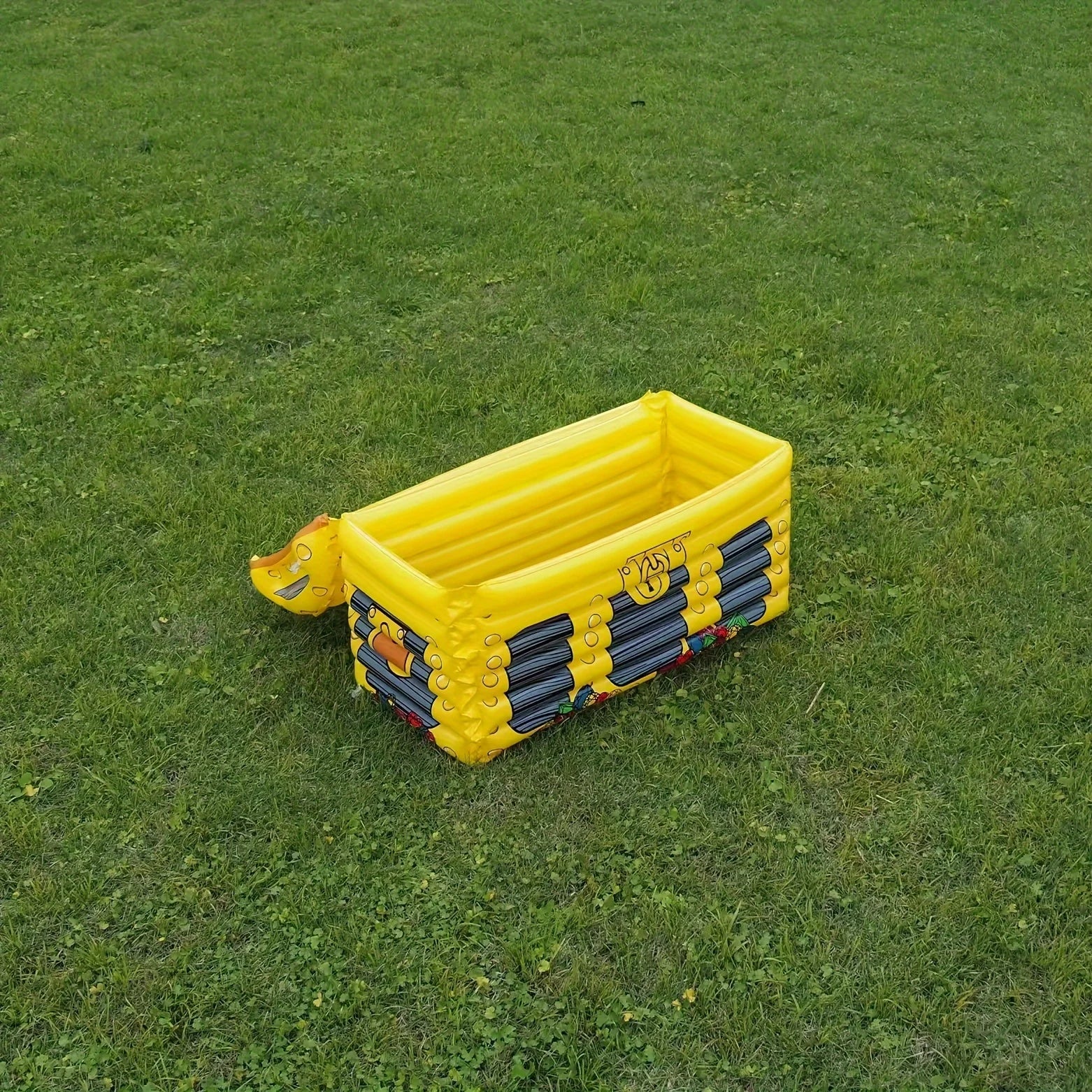 Inflatable Treasure Chest Cooler opened on a grassy lawn for an outdoor party setup