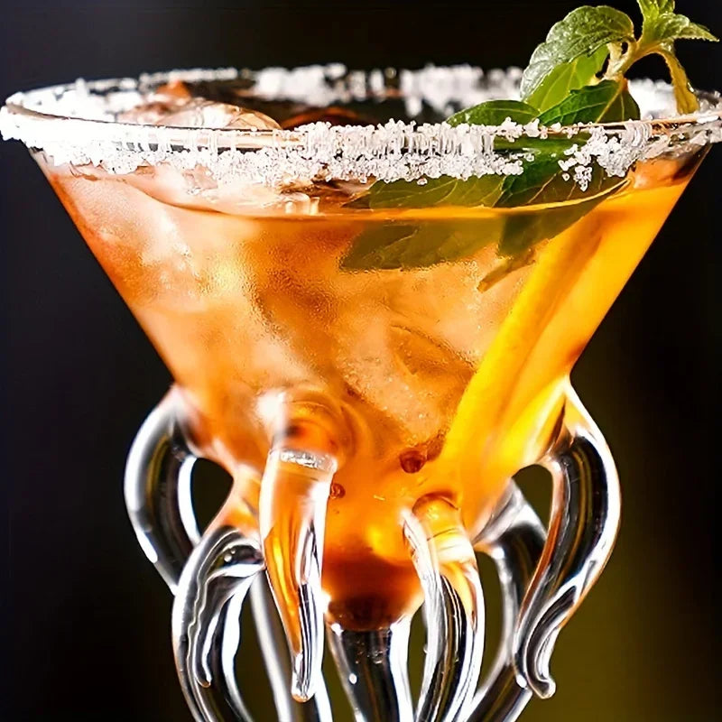 Jellyfish Cocktail Glass close-up showing a coated rim, amber drink, ice, mint, and upper tentacle details.