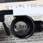 Jeweler Magnifying Glasses lens enlarging printed text to demonstrate close-up reading detail
