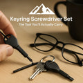 HighPeak Keyring Screwdriver Set in black steel with flat and Phillips heads clipped to keys on a wooden table.
