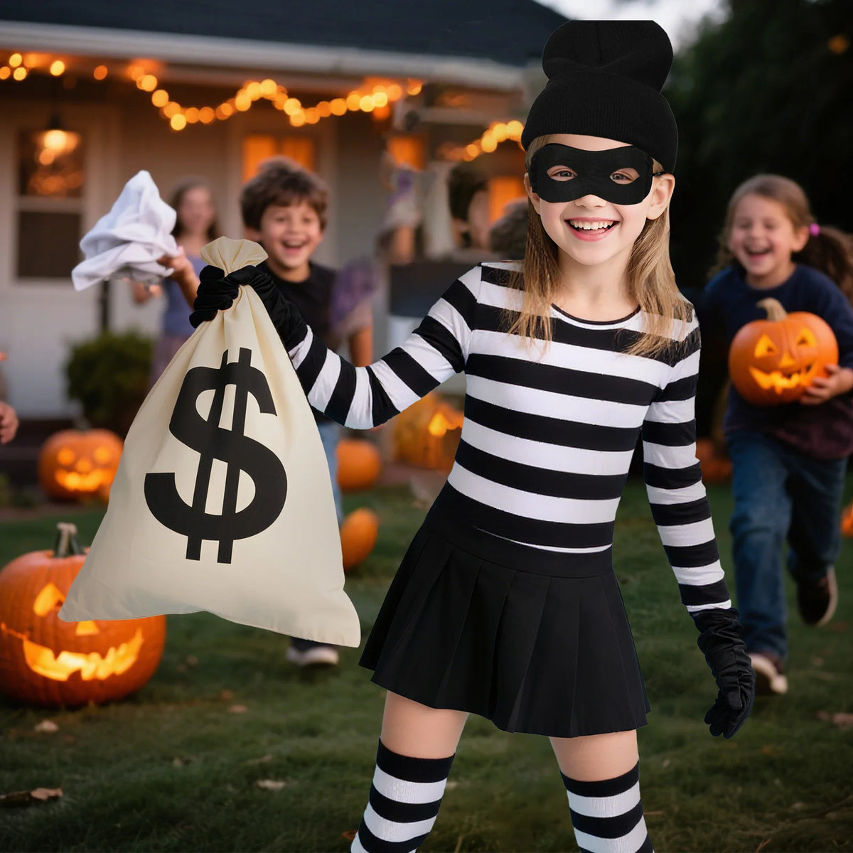 Child wearing Kids Burglar Costume Set and holding a money bag at an outdoor Halloween party with pumpkins.