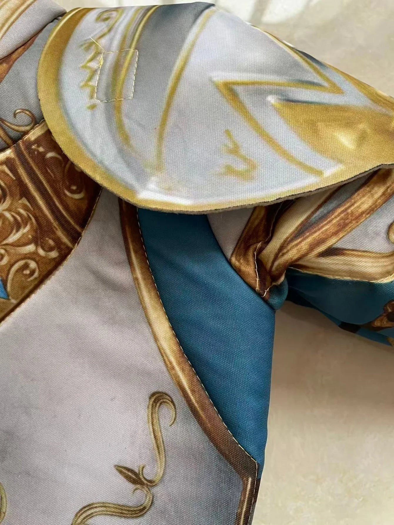 Kids Medieval Knight Costume close-up showing the printed shoulder armor and blue polyester fabric
