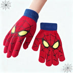 Red kids spider web glove worn on a hand beside a matching glove, both with blue ribbed cuffs.