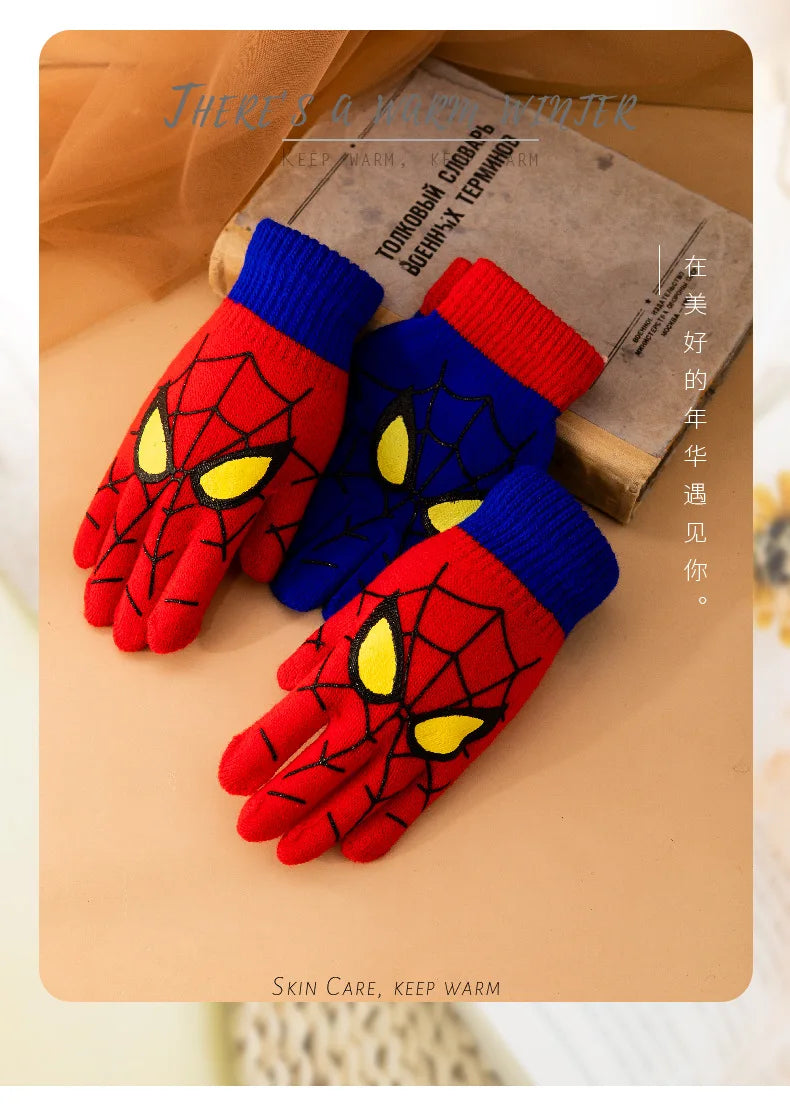 Red and blue kids spider web gloves displayed beside a book with winter-themed text.