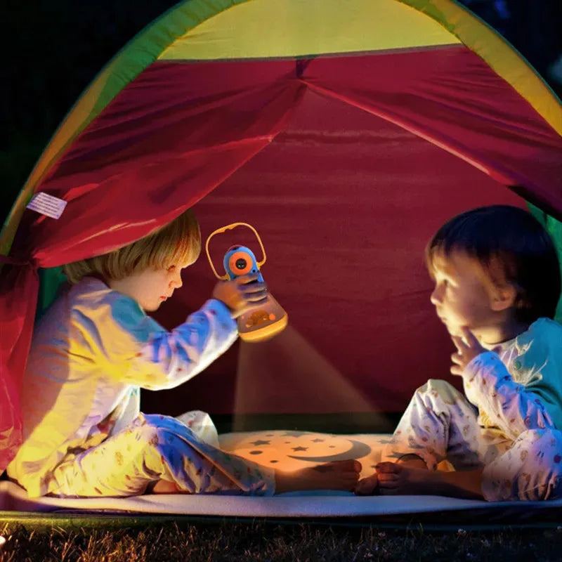 Kids Story Projector Lantern held inside a tent, casting a moon-and-star pattern between two children.