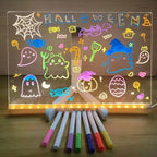 LED Acrylic Writing Board with glowing Halloween artwork and seven colored pens arranged below the panel