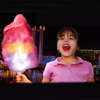 LED Cotton Candy Sticks illustrated in use with glowing cotton candy held by a child at a nighttime carnival.