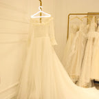 LED Glowing Clothes Hanger holding a white bridal dress in a boutique with a gold clothing rack