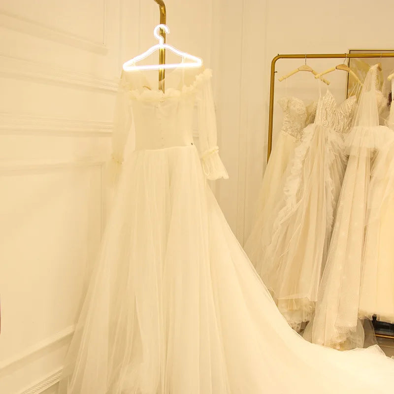 LED Glowing Clothes Hanger holding a white bridal dress in a boutique with a gold clothing rack