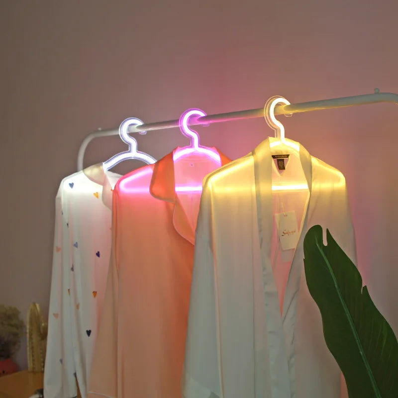 LED Glowing Clothes Hanger display with white, pink and warm-white lights shining through hanging garments
