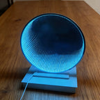 LED Infinity Tunnel Mirror glowing ice blue on a wooden table, with a white stand and visible power cable.