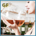 Mega Sized Wine Glass close-up showing the clear rounded bowl, amber drink, and broad circular base.