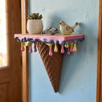 Melting Ice Cream Shelf in Colorful finish on a blue wall with a plant and small decor