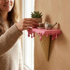 Melting Ice Cream Shelf in Pink as a person arranges a plant beside miniature decor