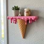 Melting Ice Cream Shelf in Pink mounted by a window with a plant and decorative candle