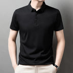 Man wearing the black Men's Valor Textured Polo with light trousers