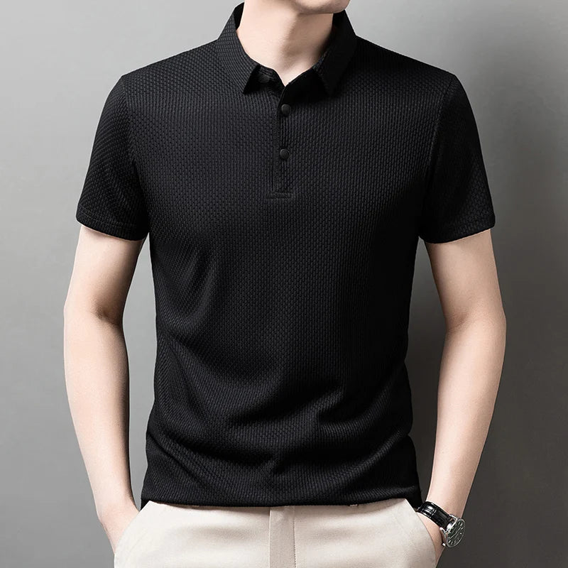 Man wearing the black Men's Valor Textured Polo with light trousers