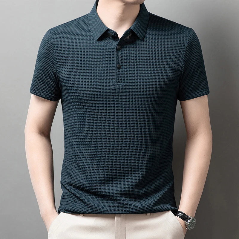 Man wearing the blue Men's Valor Textured Polo with light trousers
