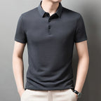 Man wearing the gray Men's Valor Textured Polo with light trousers