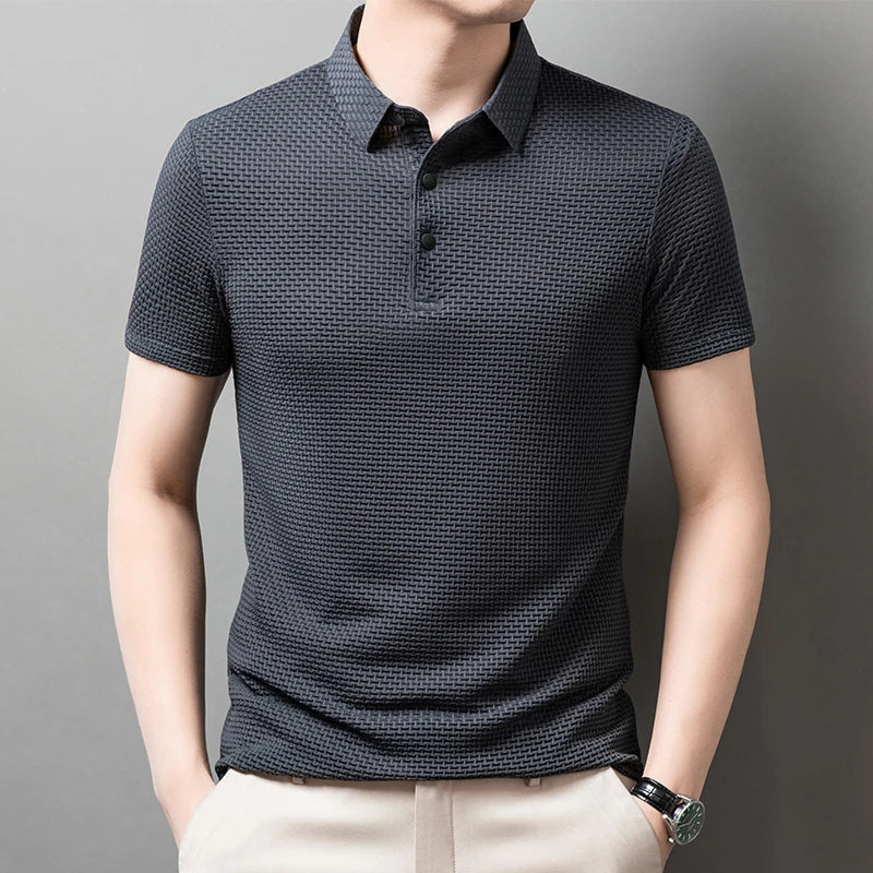 Man wearing the gray Men's Valor Textured Polo with light trousers