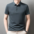 Man wearing the green Men's Valor Textured Polo with light trousers