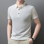 Man wearing the white Men's Valor Textured Polo in an angled pose