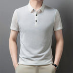 Man wearing the white Men's Valor Textured Polo with light trousers
