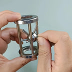Metal Cage Challenge close-up showing hands positioning the spiked ball between the cage rods