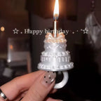 Mini Birthday Cake Ring in white held beneath a lit candle, with a happy birthday message behind it.