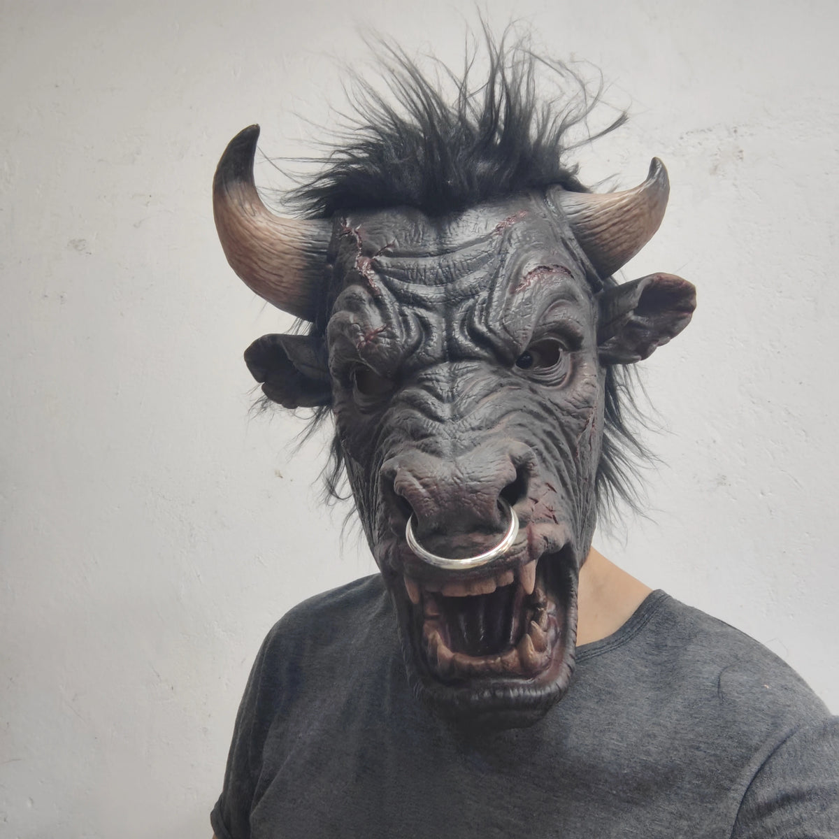 Minotaur Costume Mask worn with a gray T-shirt, showing the adult fit, upright black hair and curved horns.