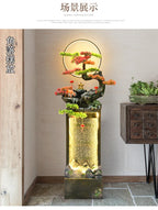 Moonlit Bonsai Waterfall displayed in an indoor corner beside a raised wooden drawer cabinet and greenery.